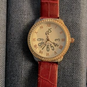 DS gold round faced watch with rhinestone edging.